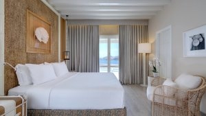 foto zimmer mit grossen weissen bett und grosser terrassentür mit meerblick und vorhängen davor im luxuriösen hochklassigen exklusiven designer hotel santa marina auf mykonos in griechenland europa
